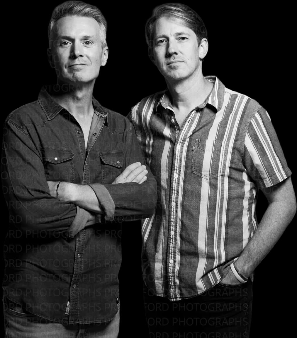 Brian Eichenberger and Chris Cron together in a black-and-white studio portrait